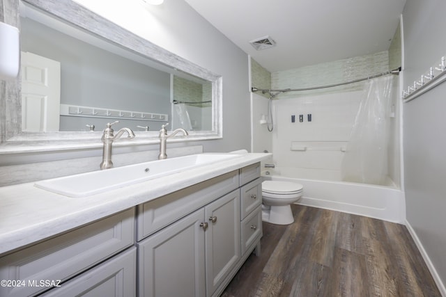 full bathroom featuring vanity, hardwood / wood-style floors, shower / bathtub combination with curtain, and toilet