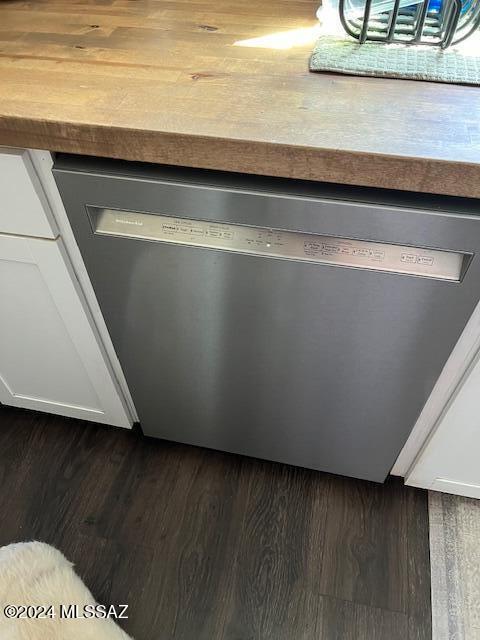 room details featuring dishwasher and dark wood-type flooring