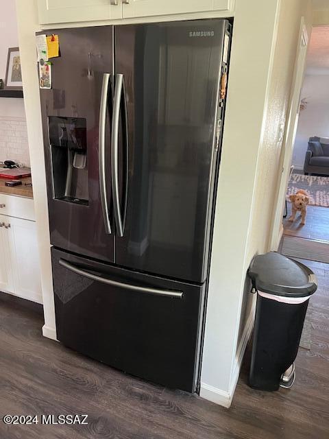 details with decorative backsplash, stainless steel fridge with ice dispenser, dark hardwood / wood-style flooring, and white cabinetry