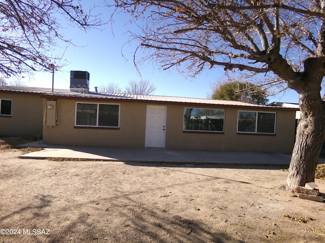 rear view of house with central AC and a patio area