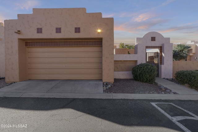 pueblo revival-style home with a garage