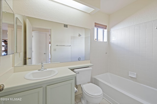 full bathroom featuring vanity, tiled shower / bath combo, and toilet