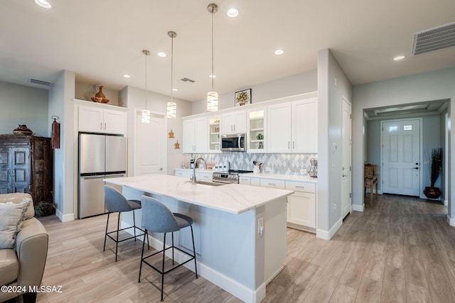 kitchen featuring backsplash, white cabinets, and stainless steel appliances