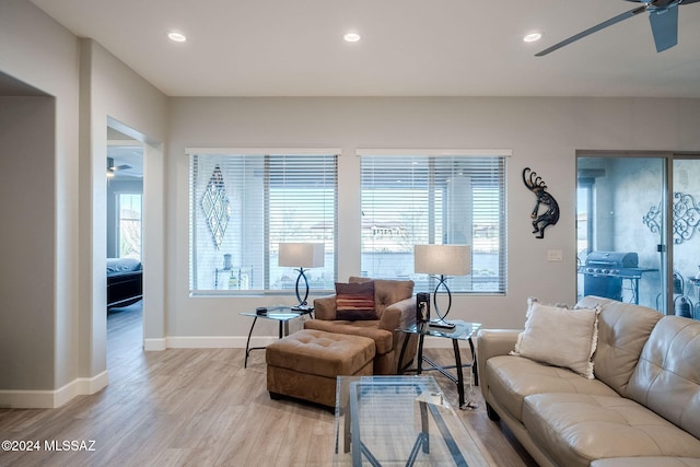 living room featuring ceiling fan and light hardwood / wood-style floors