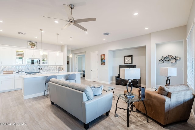 living room featuring ceiling fan and light wood-type flooring