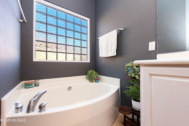 bathroom with a washtub and tile patterned flooring