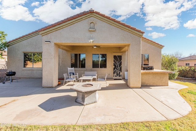 back of property with a patio, a fire pit, and ceiling fan