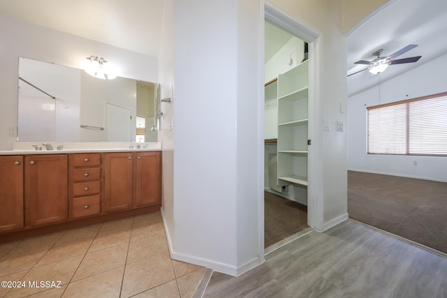 bathroom featuring ceiling fan, vanity, and lofted ceiling