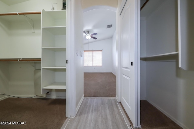 interior space with light hardwood / wood-style flooring, vaulted ceiling, and ceiling fan