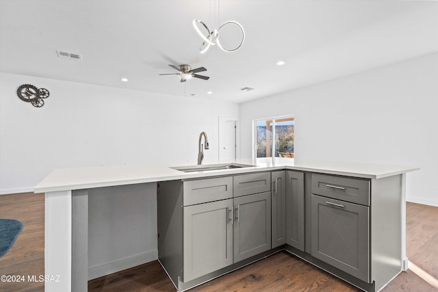 kitchen featuring ceiling fan, dark wood-type flooring, sink, pendant lighting, and gray cabinets