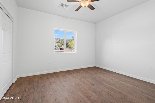unfurnished room with ceiling fan and dark wood-type flooring