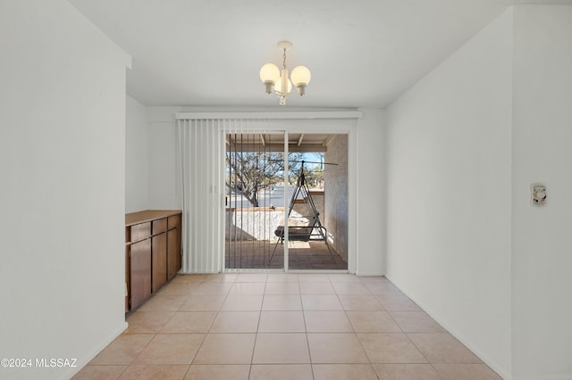 unfurnished dining area featuring light tile patterned floors and an inviting chandelier