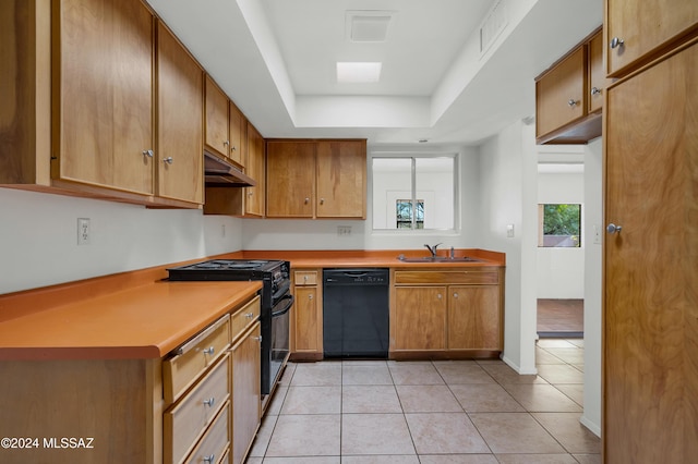 kitchen featuring a raised ceiling, sink, light tile patterned floors, and black appliances