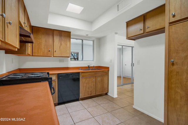 kitchen featuring a skylight, sink, black dishwasher, light tile patterned floors, and range