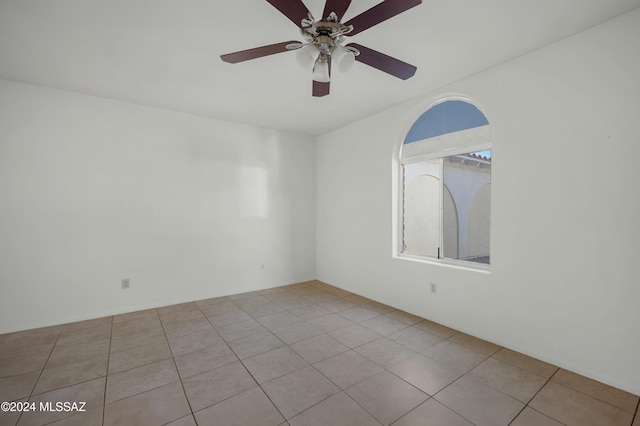 empty room with light tile patterned floors and ceiling fan