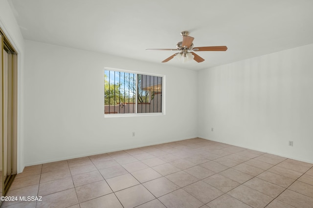 empty room featuring ceiling fan and light tile patterned floors