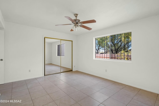 unfurnished bedroom with ceiling fan, a closet, and light tile patterned flooring