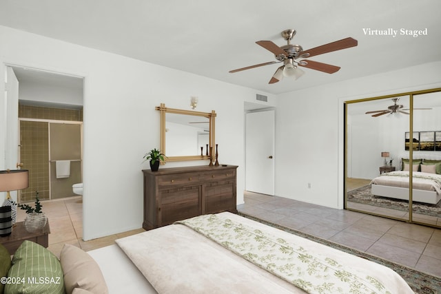 tiled bedroom with ensuite bath, ceiling fan, and a closet