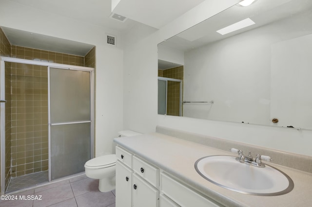 bathroom with tile patterned flooring, vanity, toilet, and an enclosed shower