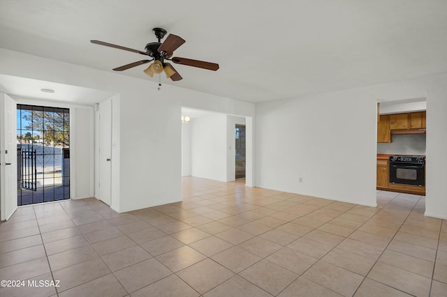 tiled spare room with ceiling fan