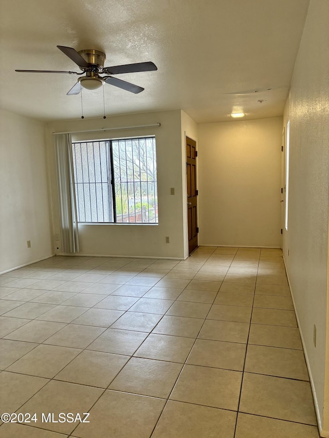 tiled empty room with ceiling fan