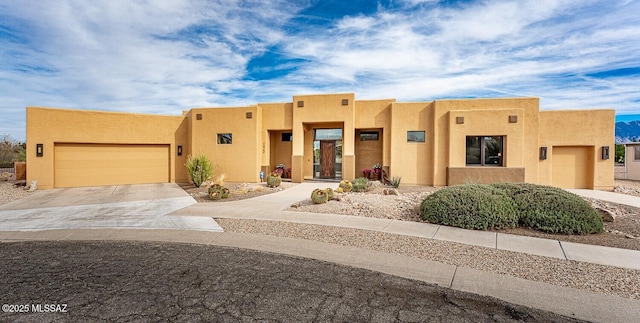 pueblo-style house featuring a garage