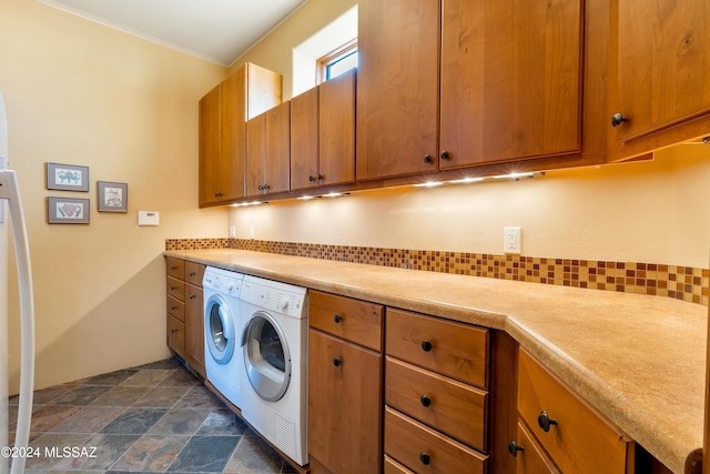 clothes washing area with cabinets and independent washer and dryer