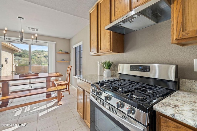 kitchen with light stone countertops, ventilation hood, light tile patterned floors, a chandelier, and stainless steel range with gas stovetop