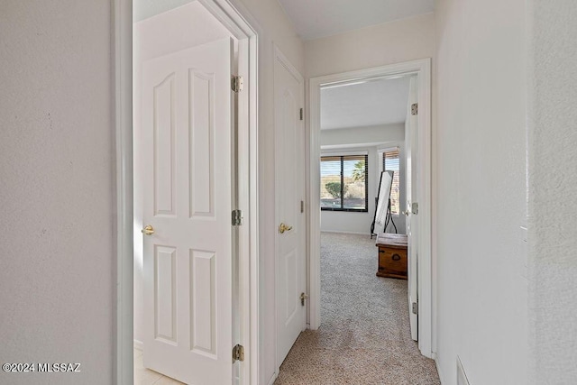 hall with light colored carpet