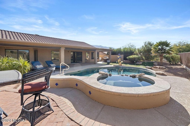 view of pool with an in ground hot tub and a patio