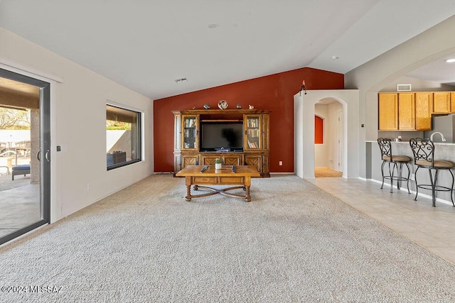 living room with light colored carpet and vaulted ceiling