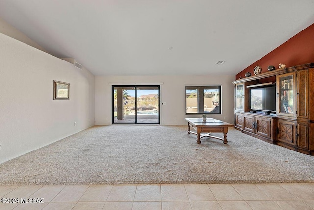 unfurnished living room with light carpet and vaulted ceiling