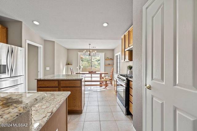 kitchen with pendant lighting, light tile patterned flooring, a notable chandelier, a kitchen island, and stainless steel appliances