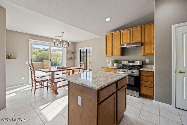 kitchen featuring stainless steel gas range oven, vaulted ceiling, pendant lighting, an inviting chandelier, and a center island