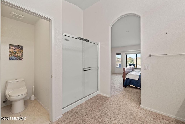 bathroom featuring an enclosed shower and toilet