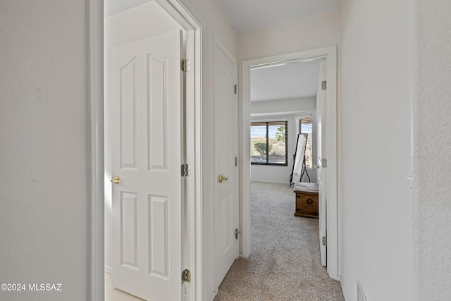 corridor featuring light colored carpet