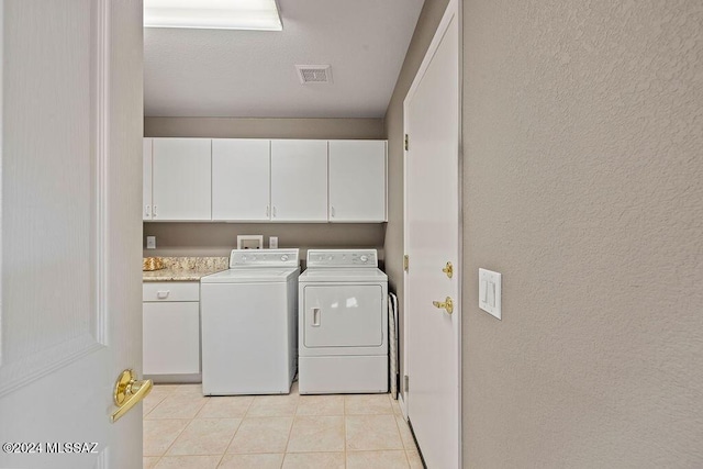 washroom with light tile patterned floors, cabinets, and independent washer and dryer