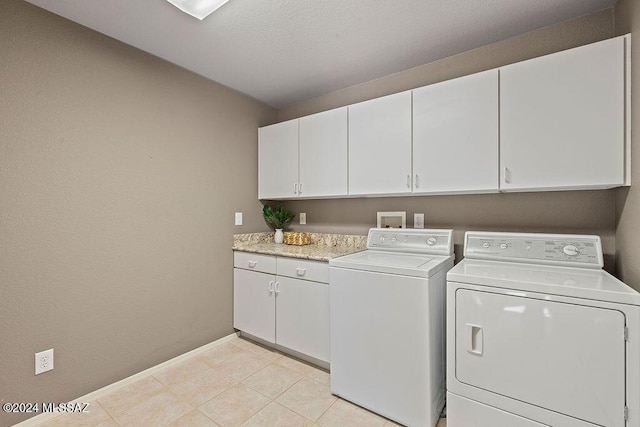 laundry room featuring cabinets, separate washer and dryer, and light tile patterned floors