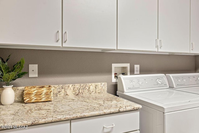 washroom featuring washer and clothes dryer and cabinets