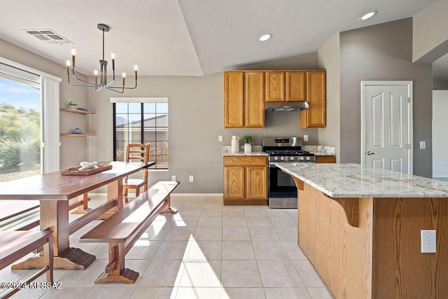 kitchen with pendant lighting, lofted ceiling, stainless steel range with gas cooktop, light tile patterned floors, and a notable chandelier