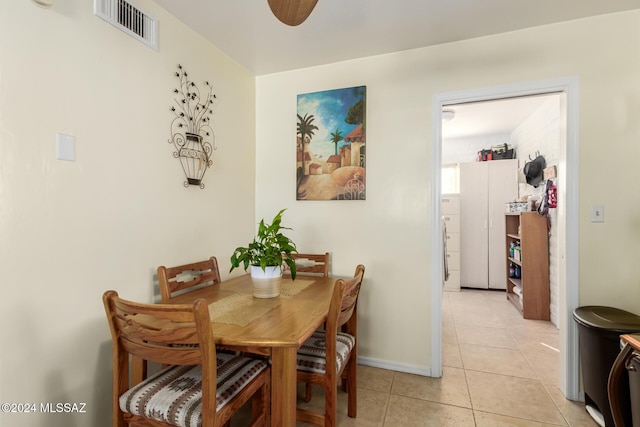 tiled dining space with ceiling fan