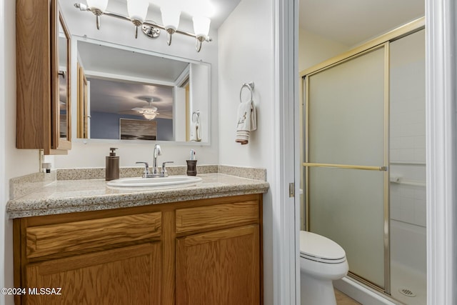 bathroom with vanity, toilet, walk in shower, and ceiling fan