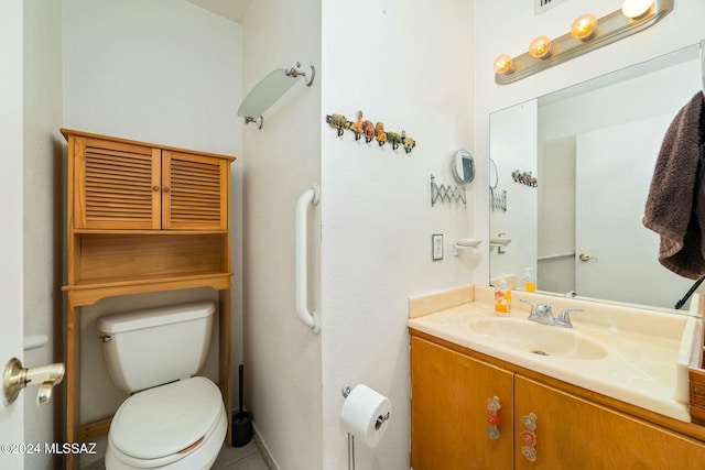 bathroom with tile patterned flooring, vanity, and toilet