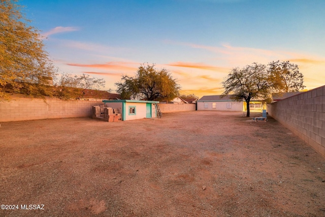 yard at dusk featuring an outbuilding