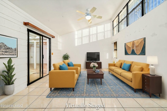 tiled living room with a towering ceiling and ceiling fan