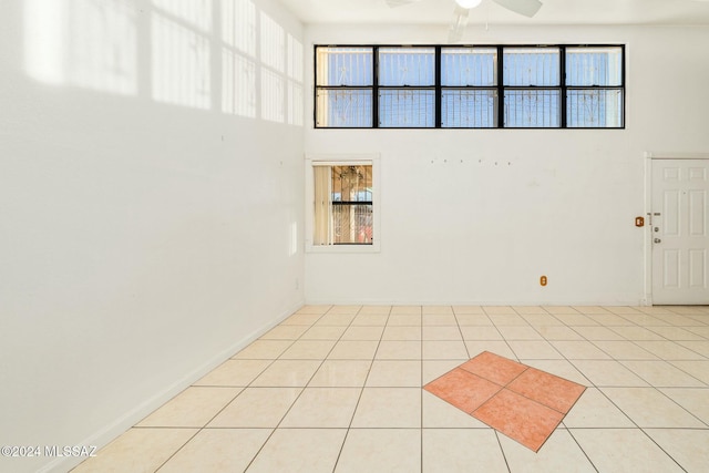 unfurnished room with ceiling fan, a healthy amount of sunlight, and light tile patterned flooring