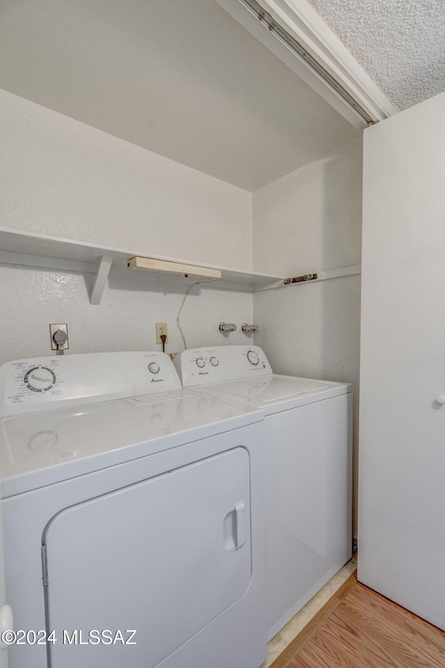 laundry room with independent washer and dryer and light hardwood / wood-style floors