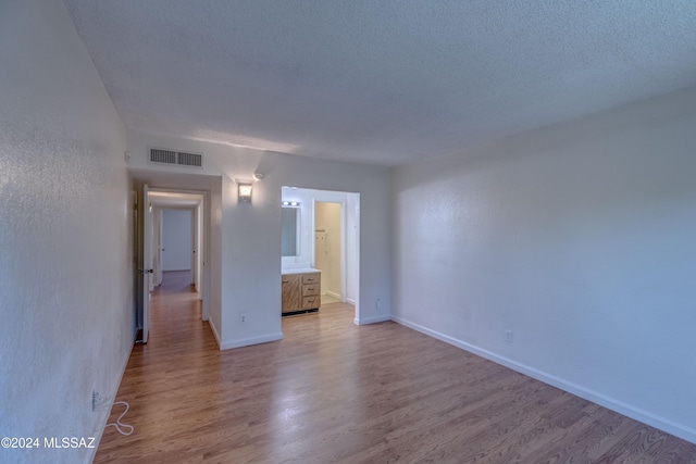 empty room featuring light hardwood / wood-style flooring and a textured ceiling