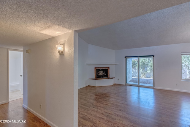 unfurnished living room with hardwood / wood-style flooring and a textured ceiling