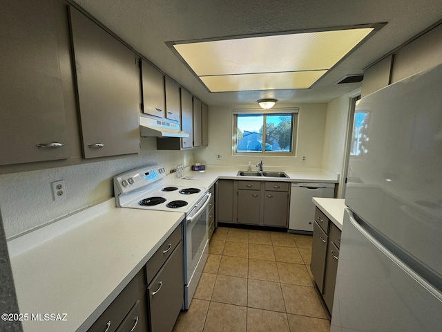 kitchen with sink, white appliances, gray cabinets, and light tile patterned flooring